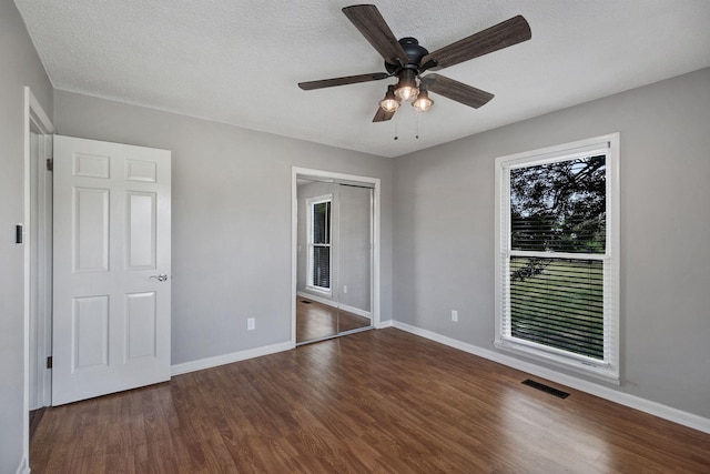 unfurnished bedroom with wood finished floors, visible vents, and baseboards