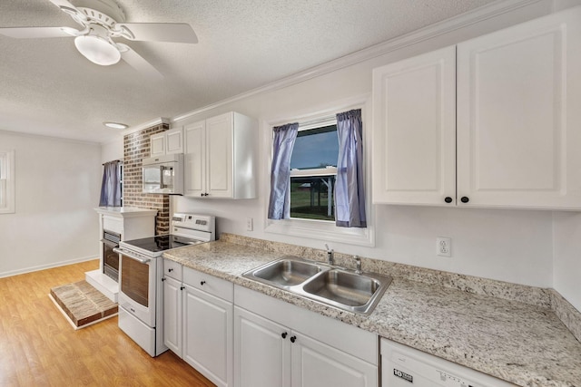 kitchen with white cabinetry, a sink, white appliances, a textured ceiling, and ceiling fan