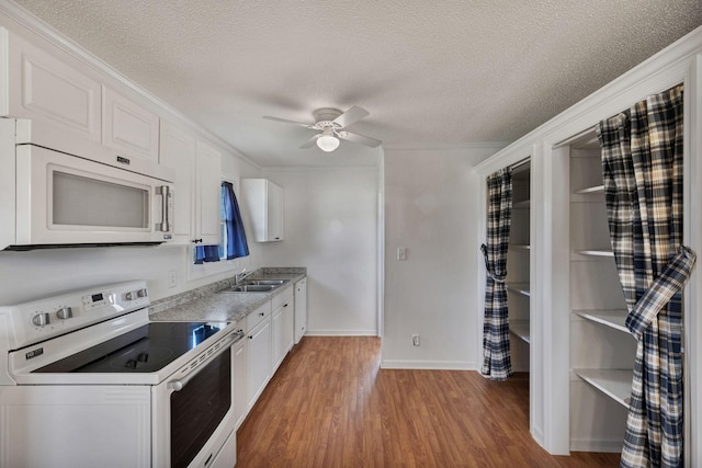 kitchen with a ceiling fan, a sink, white appliances, light wood-style flooring, and white cabinetry