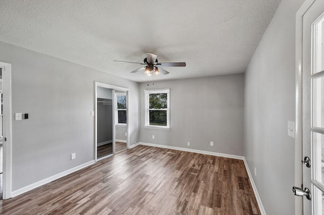 unfurnished bedroom featuring baseboards, wood finished floors, and a textured ceiling