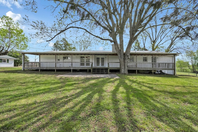 back of house with french doors, a lawn, and a deck
