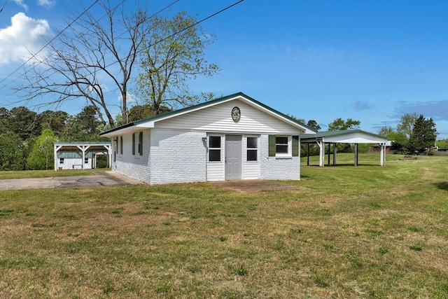 view of front of property with a carport, a front lawn, and brick siding