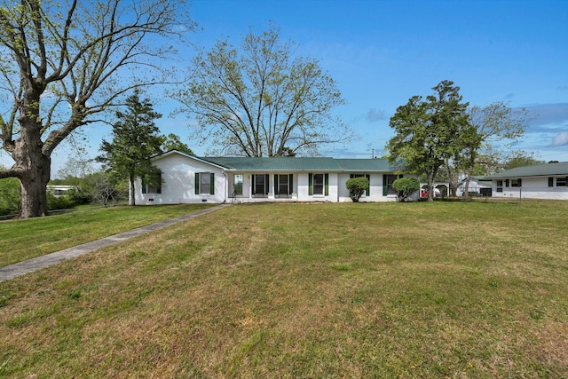 ranch-style home featuring a front lawn and metal roof