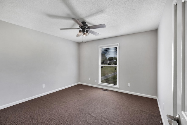 spare room with a textured ceiling, ceiling fan, dark carpet, baseboards, and visible vents