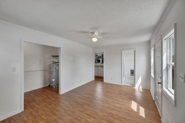 interior space with water heater, a textured ceiling, and crown molding