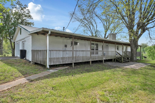 exterior space with a chimney, fence, a front lawn, brick siding, and a deck