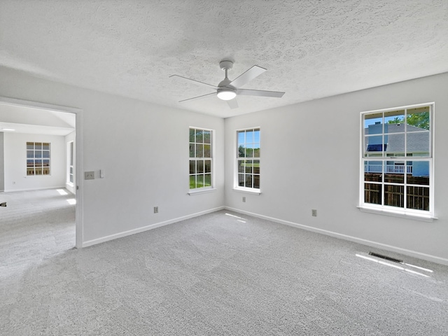 spare room featuring plenty of natural light, a ceiling fan, and baseboards