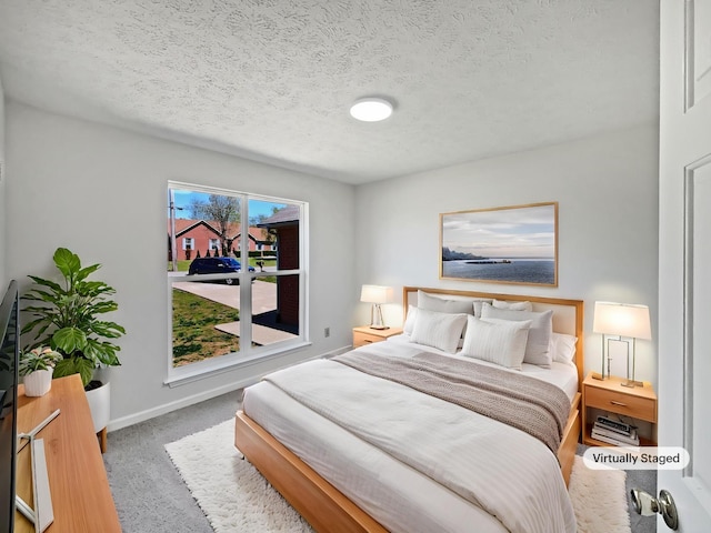 bedroom with a textured ceiling, carpet flooring, and baseboards