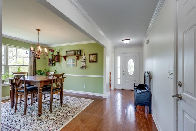 dining space featuring an inviting chandelier, a wealth of natural light, dark wood-type flooring, and crown molding