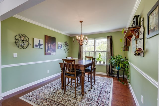 dining space featuring ornamental molding, baseboards, a notable chandelier, and wood finished floors