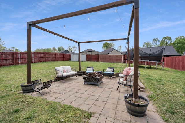 view of patio / terrace featuring a fenced backyard, a shed, an outbuilding, a fire pit, and a trampoline