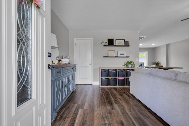 entrance foyer with visible vents, a textured ceiling, and dark wood finished floors