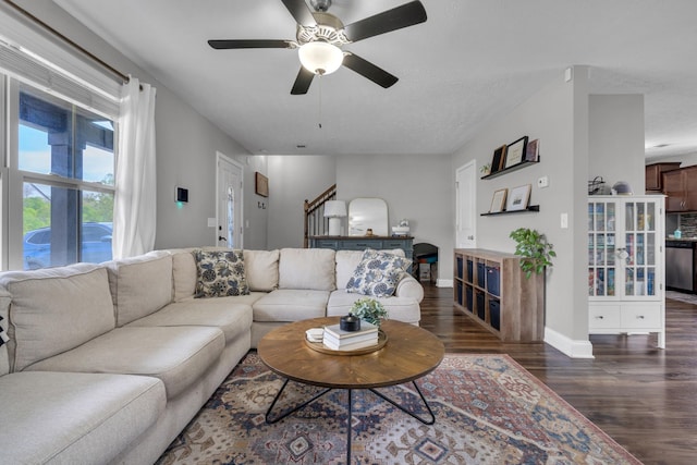 living area with baseboards, wood finished floors, stairs, and ceiling fan