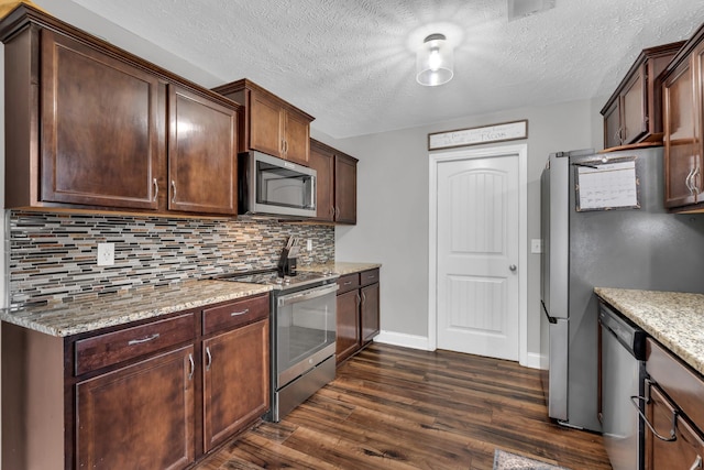 kitchen with light stone counters, a textured ceiling, decorative backsplash, dark wood finished floors, and appliances with stainless steel finishes