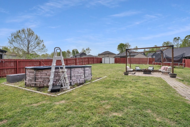 view of yard with a patio area, a fenced backyard, a storage shed, and a trampoline