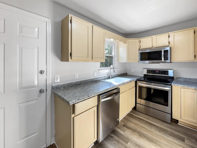 288 Donna Dr Unit F, Hendersonville, TN 37075 - kitchen featuring cream cabinetry, appliances with stainless steel finishes, a sink, and light wood-style flooring