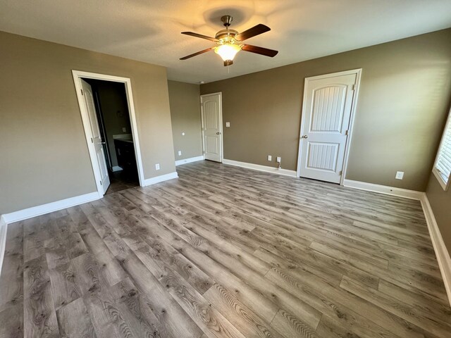 144 Sycamore Hill Dr, Clarksville, TN 37042 - unfurnished bedroom with connected bathroom, baseboards, a ceiling fan, and wood finished floors