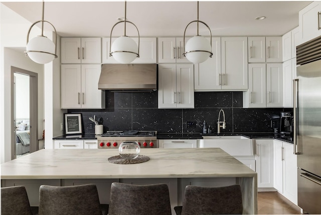 1616 W End Ave Unit 1803, Nashville, TN 37203 - kitchen featuring a sink, built in fridge, decorative backsplash, pendant lighting, and exhaust hood
