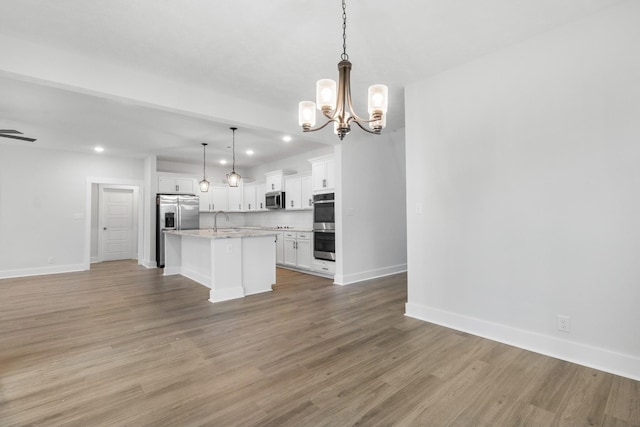 978 Alton Dr, Clarksville, TN 37043 - kitchen featuring stainless steel appliances, an inviting chandelier, a sink, open floor plan, and white cabinetry