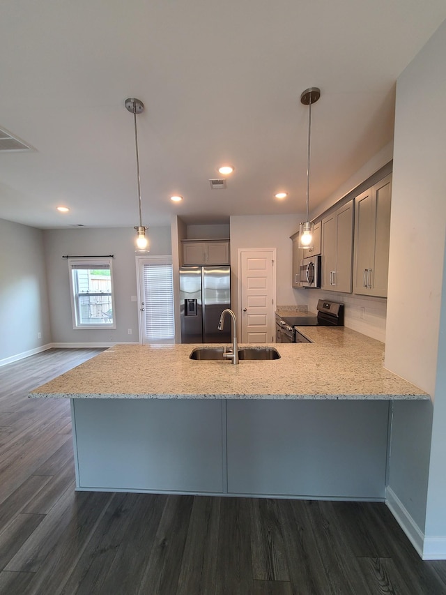 kitchen featuring gray cabinets, a sink, dark wood-type flooring, a peninsula, and appliances with stainless steel finishes