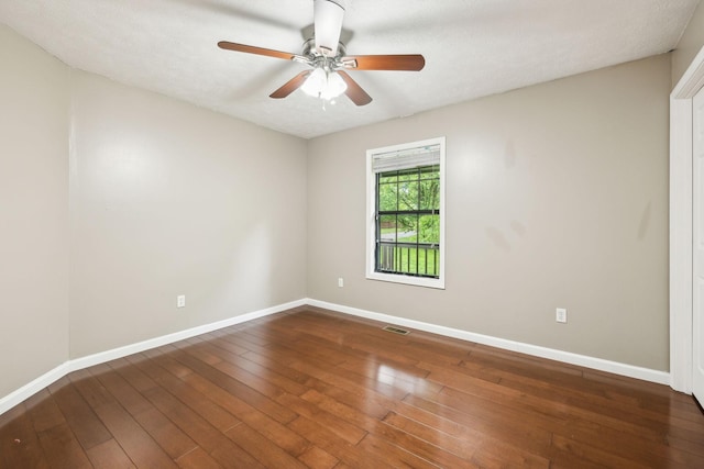empty room with visible vents, ceiling fan, hardwood / wood-style floors, and baseboards