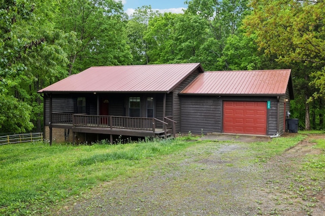 rustic home featuring driveway, fence, covered porch, and metal roof