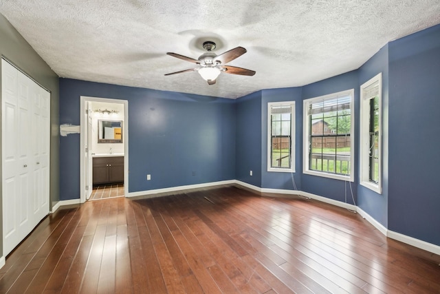 spare room with a textured ceiling, ceiling fan, hardwood / wood-style floors, and baseboards
