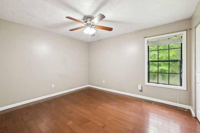 spare room with baseboards, visible vents, ceiling fan, and wood-type flooring
