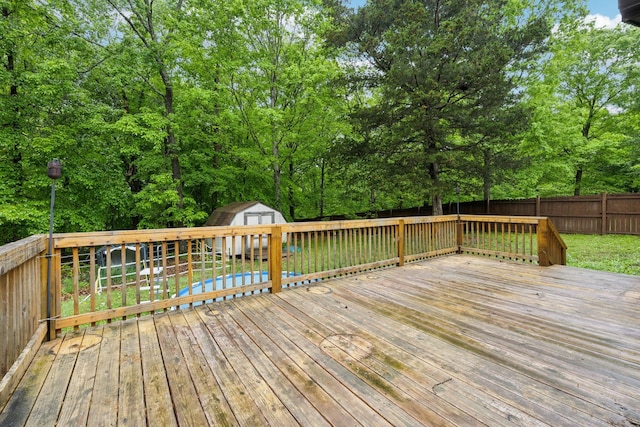 deck with a storage unit, a yard, an outbuilding, and a fenced backyard