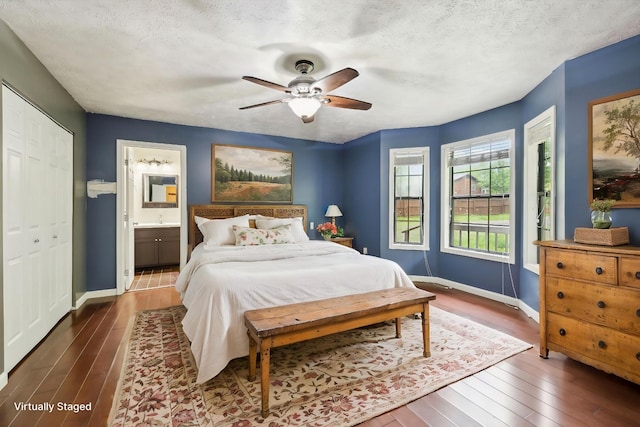 bedroom with connected bathroom, a ceiling fan, hardwood / wood-style flooring, and baseboards