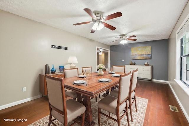 dining area featuring a wealth of natural light, a ceiling fan, visible vents, baseboards, and wood finished floors