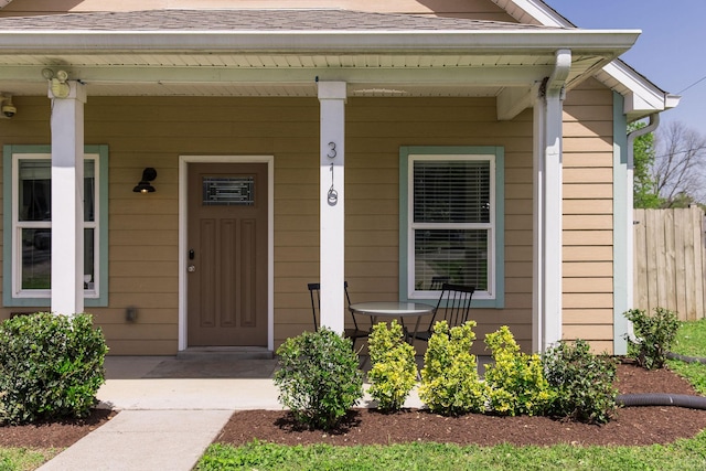 property entrance featuring a porch and fence