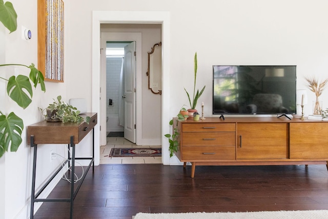 interior space featuring baseboards, ensuite bath, and dark wood-style floors