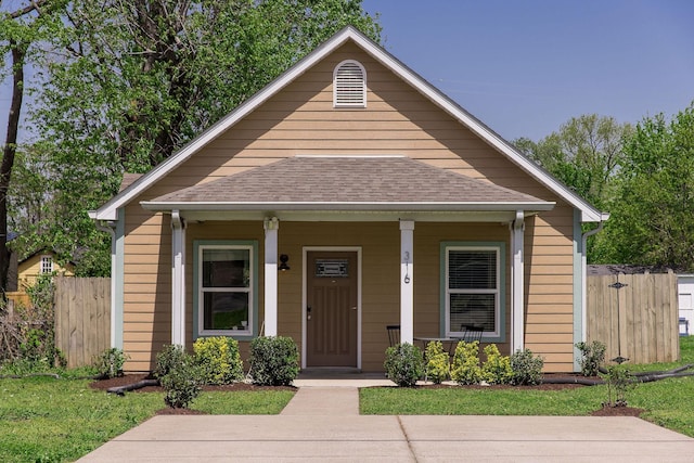 bungalow with fence, a shingled roof, and covered porch