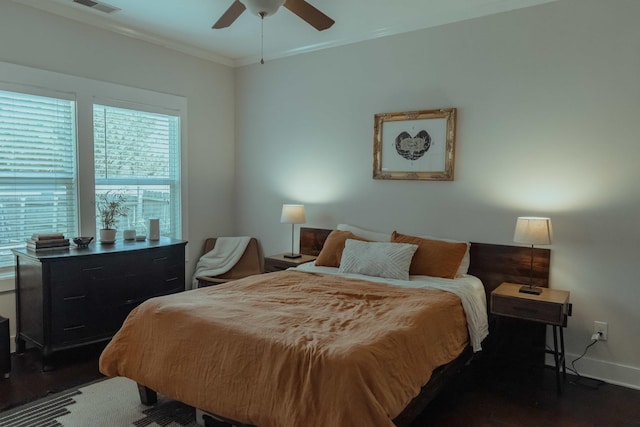 bedroom with a ceiling fan, crown molding, baseboards, dark wood-style flooring, and visible vents