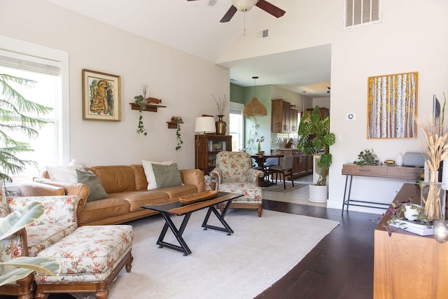 living room with dark wood-type flooring, visible vents, high vaulted ceiling, and ceiling fan