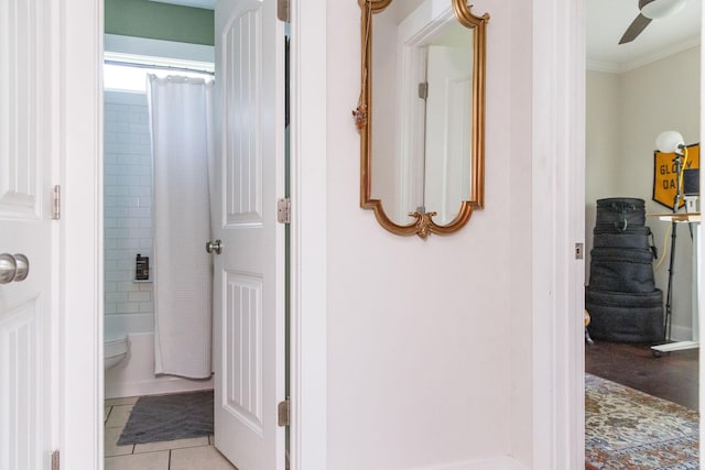 hallway with crown molding and light tile patterned floors