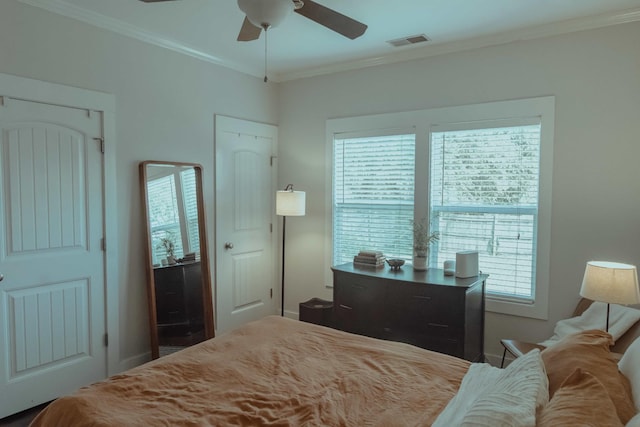 bedroom with ornamental molding, multiple windows, and visible vents