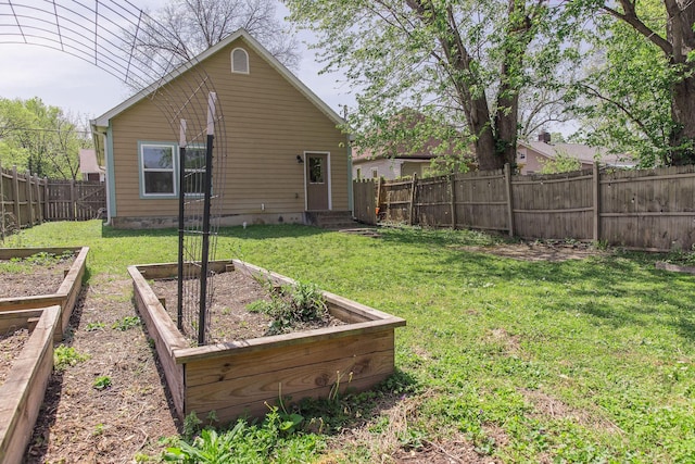 view of yard with a fenced backyard, a vegetable garden, and entry steps
