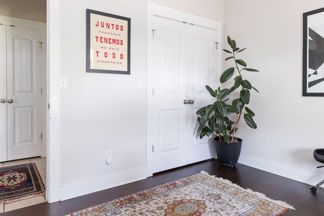 entryway with baseboards and wood finished floors