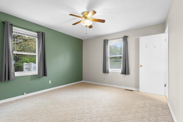 spare room featuring carpet flooring, a ceiling fan, and baseboards
