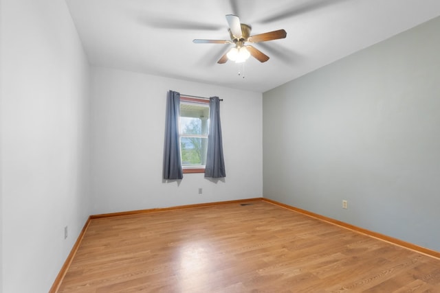 spare room with light wood-style floors, a ceiling fan, and baseboards