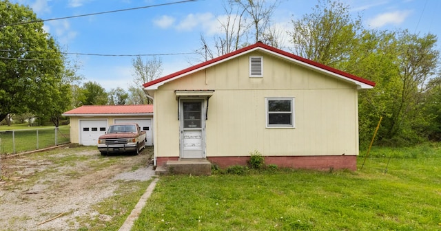 view of front of house with a garage, driveway, a front lawn, and fence