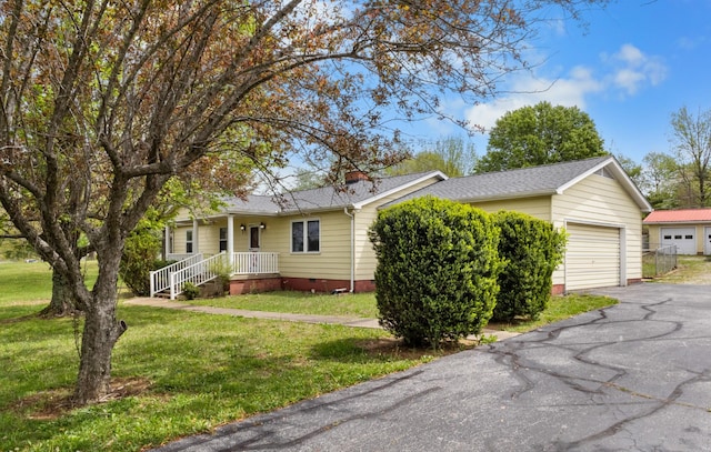 ranch-style home featuring crawl space, aphalt driveway, a shingled roof, and a front yard