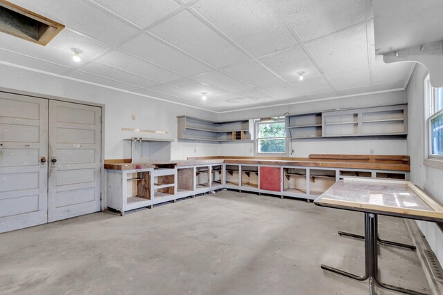 misc room featuring concrete floors and a drop ceiling
