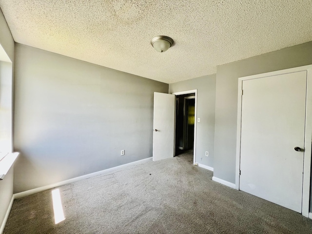 unfurnished bedroom featuring carpet floors, a textured ceiling, and baseboards