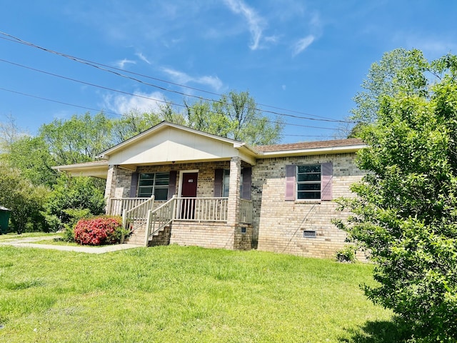 view of front of home featuring brick siding, covered porch, crawl space, and a front yard