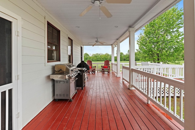 wooden terrace with covered porch, ceiling fan, and area for grilling