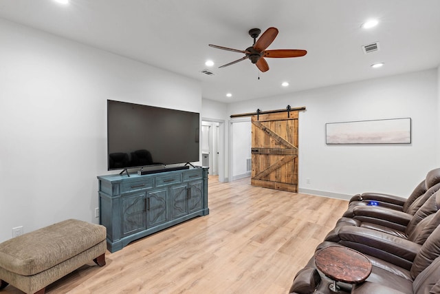 living room with ceiling fan, visible vents, a barn door, recessed lighting, and light wood-style flooring
