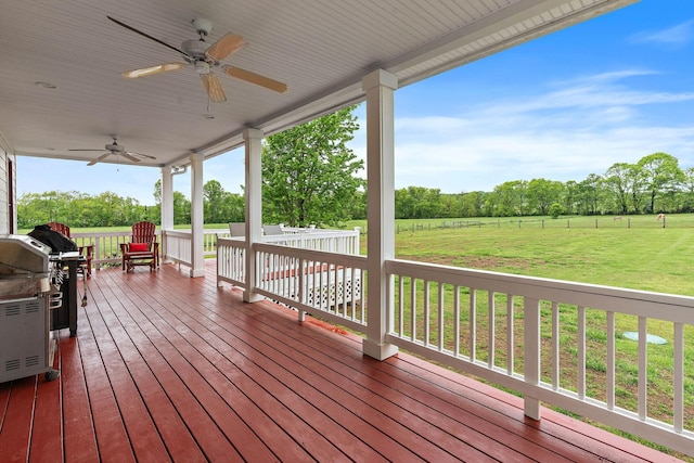 wooden terrace with a lawn, a ceiling fan, and grilling area